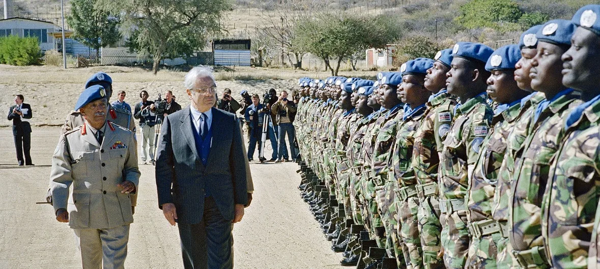 Javier Pérez de Cuéllar, el Secretario General, visita las jefaturas militares del Grupo de Asistencia de Transición de la ONU (UNTAG) en la base Suiderhof, Windhoek, Namibia, en julio de 1989.UN Photo / Milton Grant